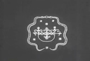 White vodou veve drawing on a dark grey ground — a starred, symmetrical crossroads emblem framed by two arcs