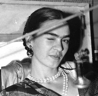 Black-and-white photo of Frida Kahlo winking, pearl necklace and heavy earrings, a wire crossing in front of her face Black-and-white photo of Frida Kahlo winking, pearl necklace and heavy earrings, a wire crossing in front of her face