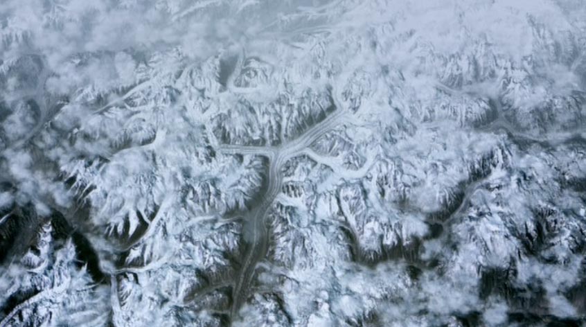 Aerial view of snowbound mountain range threaded by glaciers, clouds drifting over the ridges — Himalaya from the plane Aerial view of snowbound mountain range threaded by glaciers, clouds drifting over the ridges — Himalaya from the plane