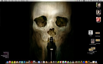 Mac desktop with a giant dark skull wallpaper, a small photo of a figure at a lectern set into its mouth like a tooth