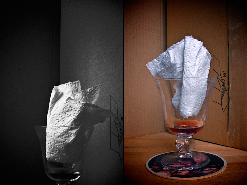 Still-life twice: a paper napkin folded into a stemmed glass with a sip of port, in black-and-white and in color against cardboard