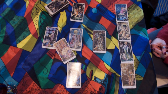 Tarot spread on a bright Kandinsky-patterned cloth: a cross layout with a side column of four cards, one card face down Tarot spread on a bright Kandinsky-patterned cloth: a cross layout with a side column of four cards, one card face down