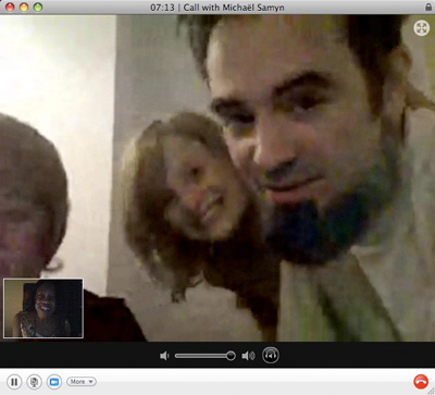 Skype call with Michaël Samyn at 07:13: he mugs close to the camera, two relatives peeking in behind, the caller smiling in the corner window