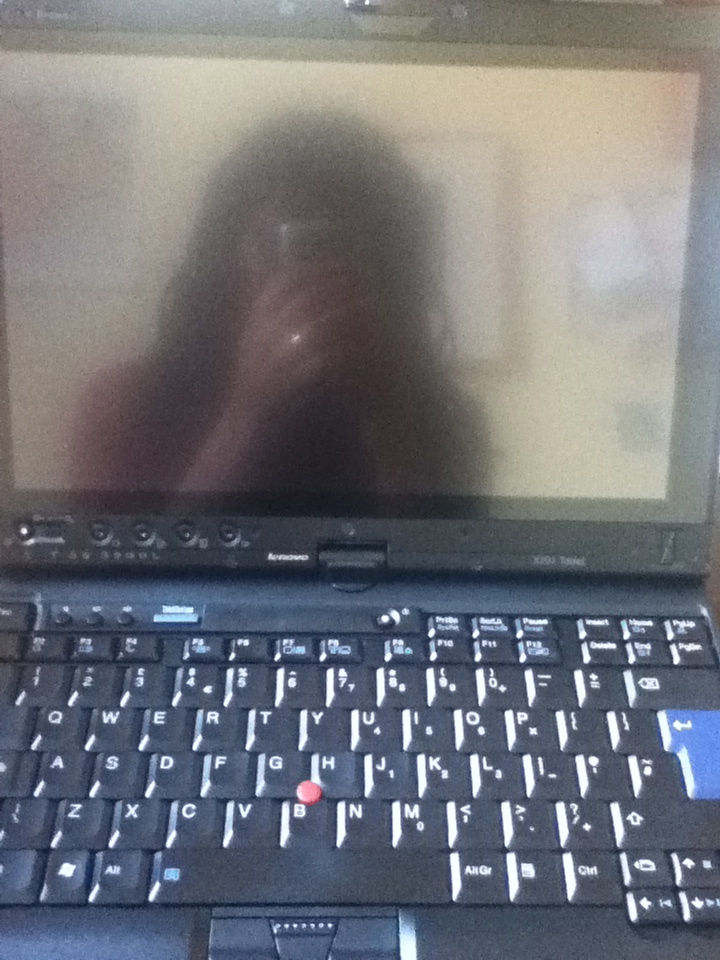 ThinkPad X201 tablet open, keyboard in the foreground; the glossy screen reflects the photographer instead of showing anything — the Eureka Maru