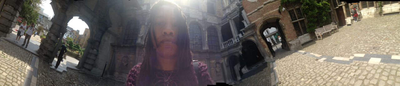 Warped panorama selfie in the courtyard of the Rubens House in Antwerp — sun flaring over the head, the baroque portico bent around both sides