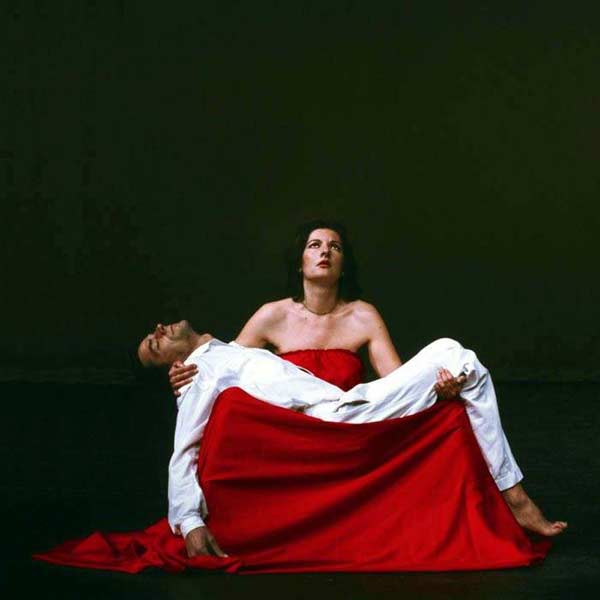 Abramović and Ulay, Pietà: he lies white-clothed across her lap over a spill of red cloth as she looks upward