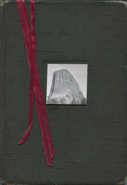 Cover of sketchbook 25: dark green cloth with a small black-and-white photo of Devils Tower and three red ribbons hanging down