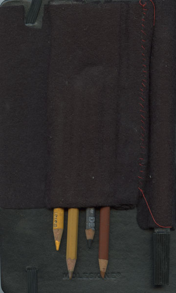 Back of sketchbook 31: a dark felt pencil roll stitched in red over a black Moleskine, four worn pencils tucked in the bottom Back of sketchbook 31: a dark felt pencil roll stitched in red over a black Moleskine, four worn pencils tucked in the bottom