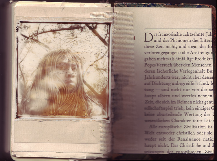 Inside back cover of sketchbook 38: a sun-bleached Polaroid self-portrait among bare branches, hair falling over the face, taped beside a German page on 18th-century literature