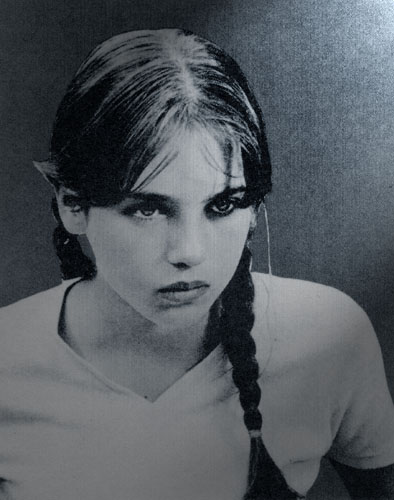 Grainy black-and-white portrait of young Isabelle Adjani with braided pigtails and dark-rimmed eyes, gazing gravely past the camera