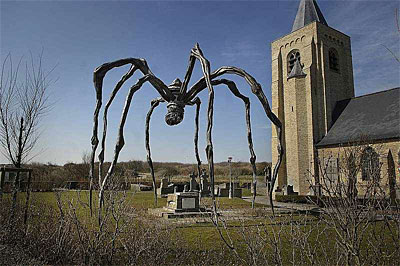 Louise Bourgeois's giant bronze spider Maman standing over James Ensor's grave beside the brick church tower of Our Lady of the Dunes, Ostend