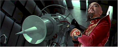 Max von Sydow as Ming the Merciless in Flash Gordon, gloating in a red high-collared uniform beside a white rocket in a rivet-walled corridor