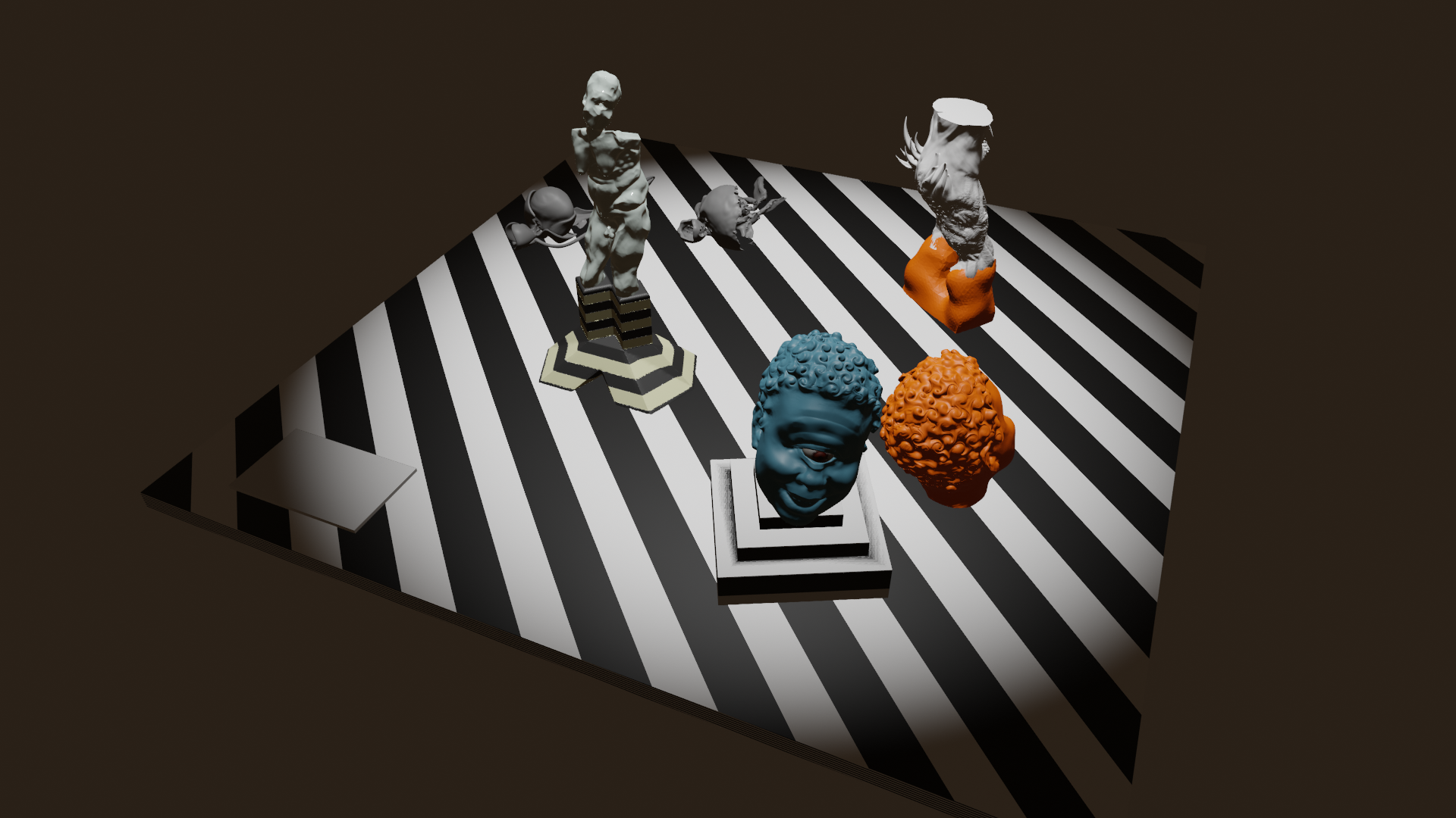 Blender simulation of a striped exhibition table: a grey torso on a ziggurat plinth, blue and orange cyclops heads, an orange-gloved fragment, and scattered skulls