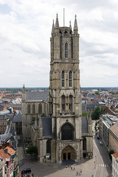 Saint Bavo's Cathedral in Ghent seen from the belfry: the great Gothic west tower rising over the city's rooftops under a white sky Saint Bavo's Cathedral in Ghent seen from the belfry: the great Gothic west tower rising over the city's rooftops under a white sky