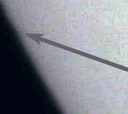 Grainy photograph of the transit of Venus: an arrow points to the planet's small dark silhouette against the Sun's blurred limb