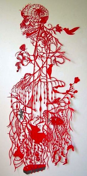 Intricate red paper-cut wall piece: a horned skull crowns a cascading tree of veins and drips sheltering small figures, birds, and a truck at its root Intricate red paper-cut wall piece: a horned skull crowns a cascading tree of veins and drips sheltering small figures, birds, and a truck at its root