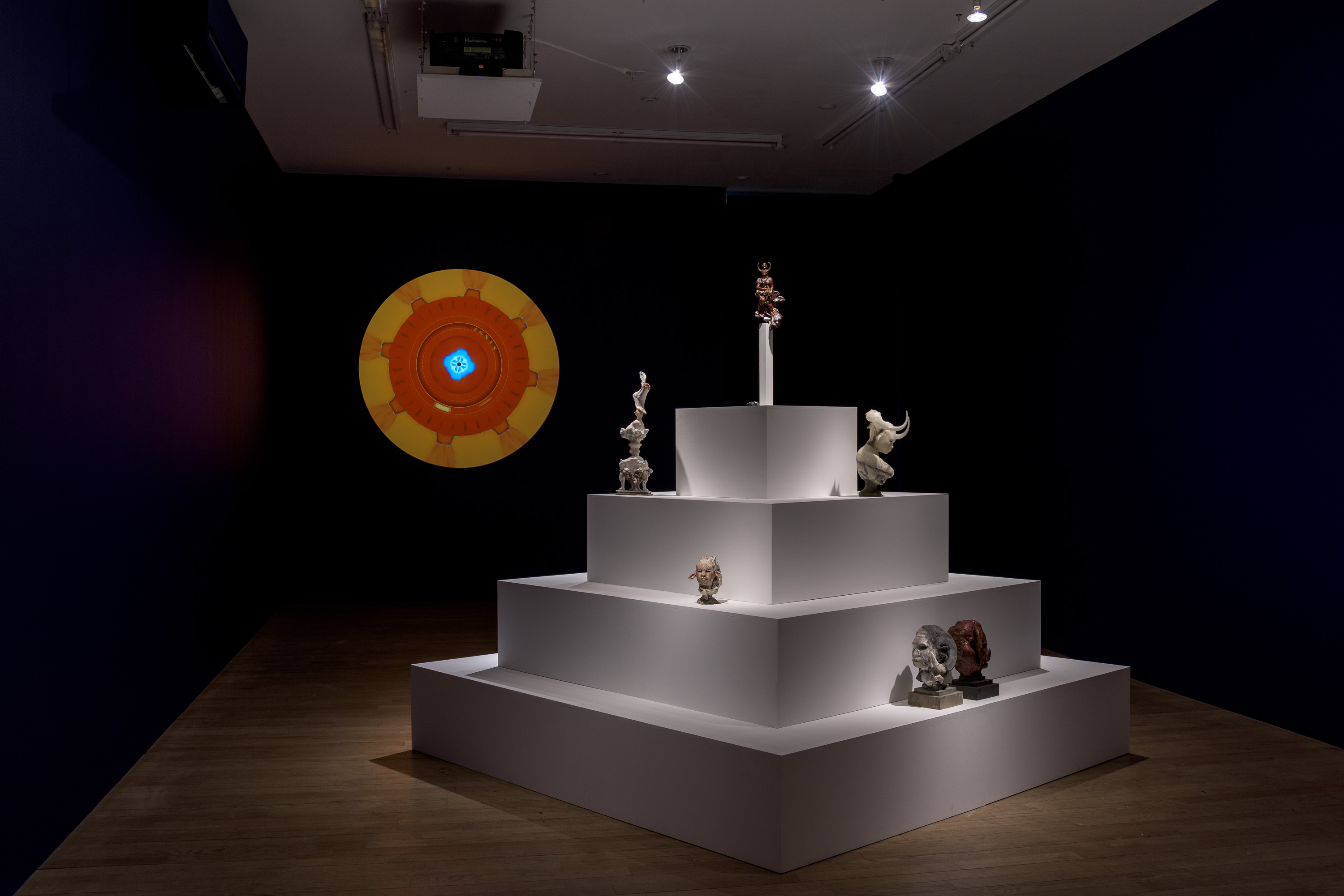 Year Zero at bitforms: the ziggurat of sculptures in the dark blue room, the projected mandala now burning orange and gold around a small blue rosette