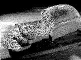 Tiny dithered black-and-white photograph of a loaf of bread with cut slices leaning against it