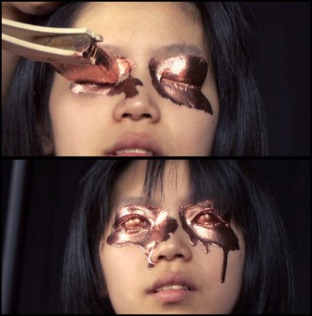 Two frames: copper leaf laid with tongs onto a girl's closed eyelids, then her face with gilded eye sockets running in metallic drips like tears