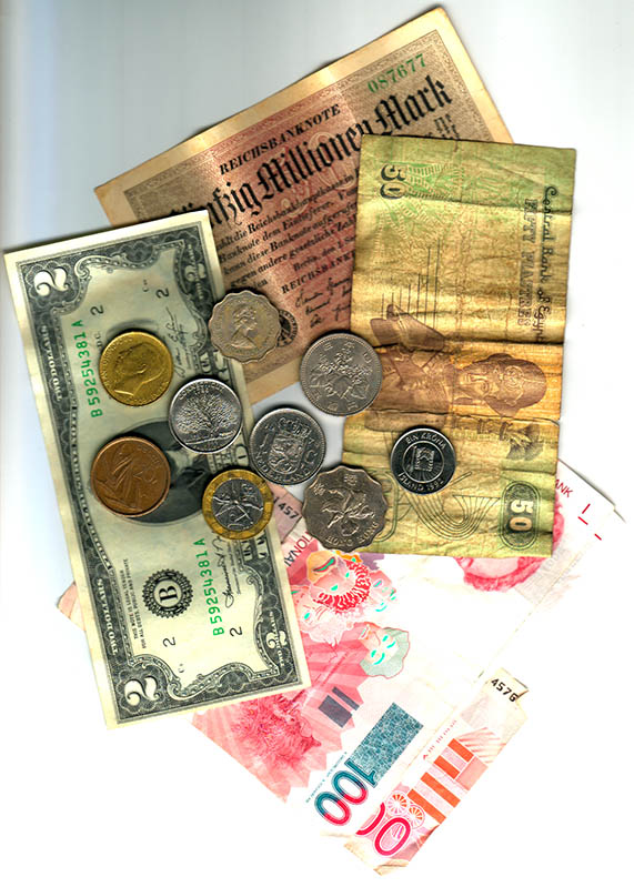 A scanned drift of currencies: a fifty-million-Mark Reichsbanknote, a US two-dollar bill, Egyptian pounds, assorted coins, and a pink hundred A scanned drift of currencies: a fifty-million-Mark Reichsbanknote, a US two-dollar bill, Egyptian pounds, assorted coins, and a pink hundred
