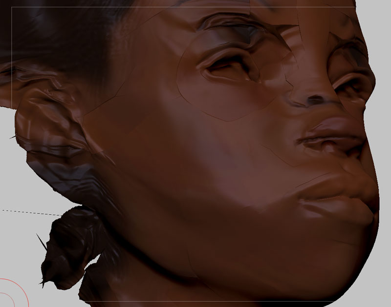 ZBrush sculpt in progress, close up: a dark-skinned female head tilted back, polygroup seams still visible across the cheek and brow, hair bound at the nape